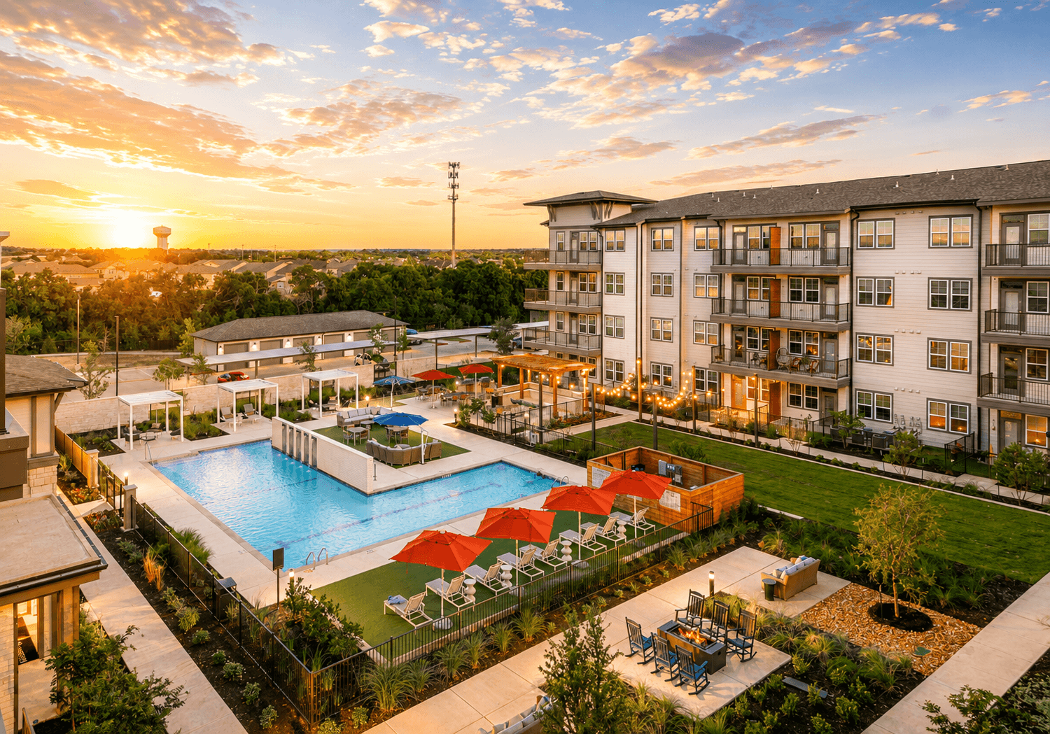 A sunset view of a pool area in a residential complex.